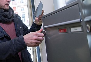 Ein Mann holt einen Brief aus dem Briefkasten - Christin Klose/dpa-tmn