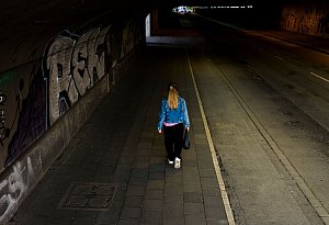 Frau läuft am Abend durch einen Tunnel mit geringer Beleuchtung - Christoph Reichwein/dpa