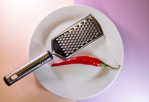 Chilischote liegt neben einer Küchenreibe - Christin Klose/dpa-tmn