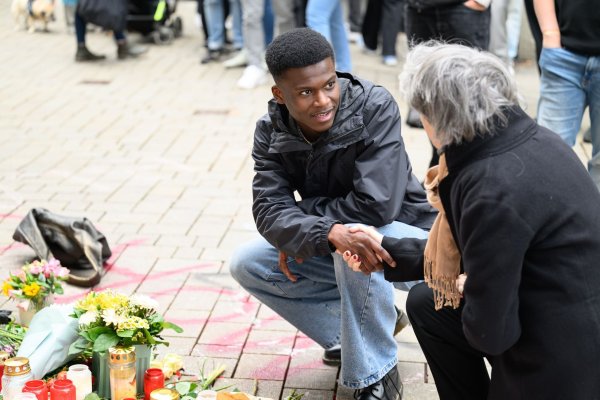 Suraj Mailitafi (l) von der Initiative «Gerechtigkeit für Lorenz» spricht mit einer Passantin an dem Ort, an dem der 21-Jährige von der Polizei erschossen wurde. - © Izabela Mittwollen/dpa