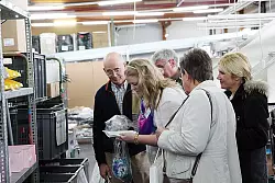 Azubi Nina Büker (mitte) erklärt Heinz Brinkmeier (links) und anderen Teilnehmern, warum Modestücke von Kunden zurückgeschickt werden - beobachtet von "Alba Moda"-Sprecherin Marita Klawun (Zweite von rechts). - © Foto: Beckschäfer