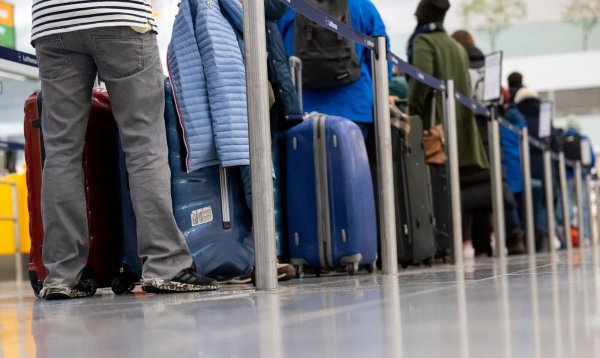 Passagiere stehen mit ihrem Gepäck an Check-in-Schaltern am Flughafen. - © Sven Hoppe/dpa/Archivbild