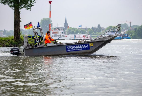 Einsatzboote des Technisches Hilfswerk (THW) fahren auf dem Rhein am Ufer entlang. - © Thomas Banneyer/dpa