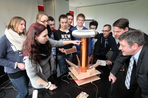 Spannend: Lara Kohlhoff (Zweite von links) erklärt Synflex-Laborleiter Heinz von der Heiden und Personalleiter Dr. Henning Martens (von rechts) den Aufbau der Tesla-Spule. Mit im Bild (von links): Sarah Deutschmann, Anita Pankratz, Jannik Braig, Meriyan Güner, Marcel Ruth, Jan Henke, Leon Siegfried und Physik-Lehrer Kai Fronda. - © Preuss