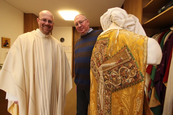 "Amtshilfe": Pfarrer Matthias Altevogt (links) probiert das katholische Messgewand an, das ihm sein Kollege Reinhold Frickenstein von der Gemeinde Heilig Geist für den "Gottesdienst anno 1300" ausleiht. Dieser hält ein prächtiges historisches Messgewand in der Hand. - © Rademacher
