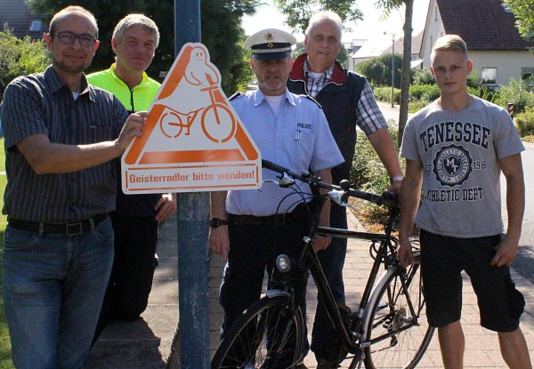 Geisterschild: Fahrradbeauftragter Jürgen Deppemeier, die Polizisten Heinz-Josef Fischer und Jürgen Hampe, Ordnungsamtsleiter Hans-Jürgen Taron und Bauhofauszubildender Christoph Freund (von links) präsentieren das Schild gegen "Geisterradfahrer". - © Dohna