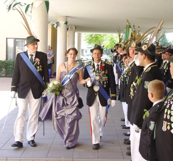 In Uniform und Ballkleid: König Detlev Goldbecker und Königin Marleen Riepe schreiten gemeinsam mit Oberst Volker Schreiber (links) die Reihe der angetretenen Schützen ab - © Schüler