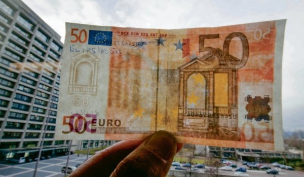 Ein gefälschter 50-Euro-Schein mit aufgedrucktem Wasserzeichen wird in der Bundesbank in Frankfurt am Main ins Licht gehalten.  - © picture alliance / dpa