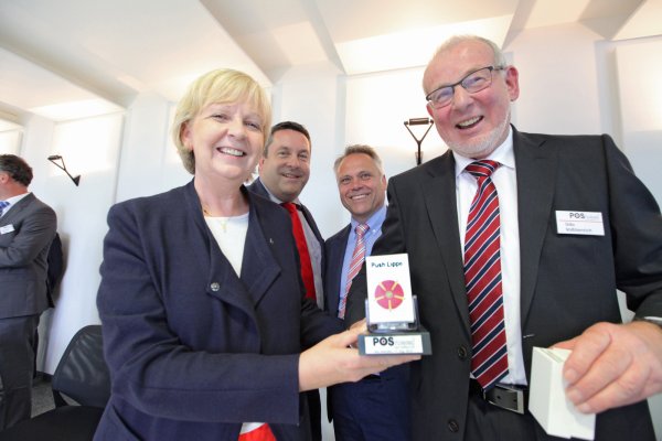 Die lippische Rose direkt im Blick: „POS“-Gründer Udo Voßhenrich überreicht Hannelore Kraft ein Warenvorschub mit besonderem Inhalt. Das freut auch Landratskandidat Axel Lehmann (Zweiter von links) und Roland Thomas, Bürgermeisterkandidat in Salzuflen. - © Vera Gerstendorf-Welle