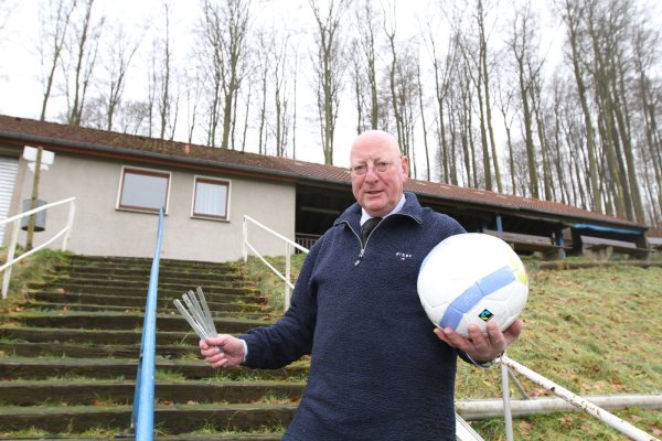 Ein Schiri, der Spaß versteht: Hermann Langenhop auf der Treppe des Westorfer Waldstadions mit dem Ball in der Hand - und natürlich einen Zollstock. - © Oliver König