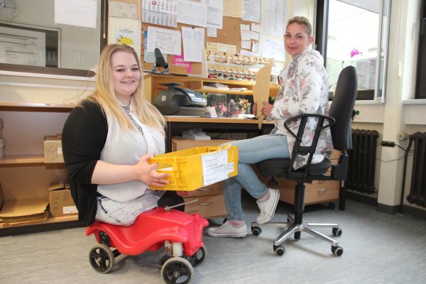 Jennifer Engelbracht (rechts) und Ann-Kathrin Wulf sortieren die Post für die einzelnen Dienststellen der Bundeswehrverwaltung. Die 19-Jährige ist am Oberschenkel amputiert und nutzt zur Fortbewegung ein Bobbycar. - © Patrick Bockwinkel(LZ)