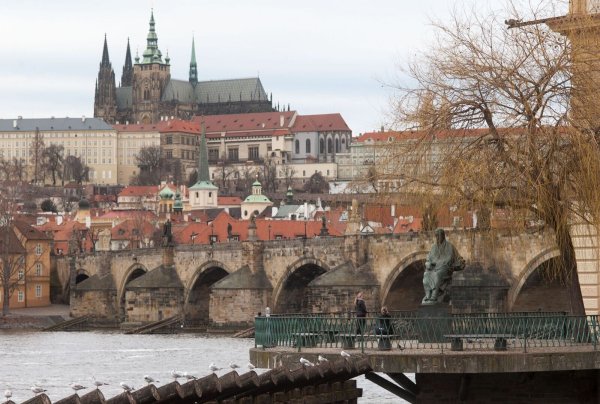 Eine Statue (rechts unten im Bild) am Ufer der Moldau in Prag erinnert an den tschechischen Komponisten Bedrich (Friedrich) Smetana, im Hintergrund die Karlsbrücke und der Hradschin mit der Prager Burg und dem Veitsdom. - © Michael Heitmann/dpa