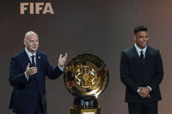 Gianni Infantino (l) und Ex-Profi Ronaldo präsentieren die Trophäe für den neuen Club-Weltmeister. - © Rebecca Blackwell/AP/dpa