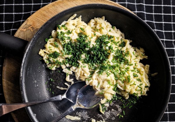 Für Kasnockerl kommen Spätzle und Käse auf den Herd und werden mit Schnittlauch bestreut - und das Ganze wird am besten direkt aus der Pfanne gegessen. - © Doreen Hassek/hauptstadtkueche.blogspot.com/dpa-tmn