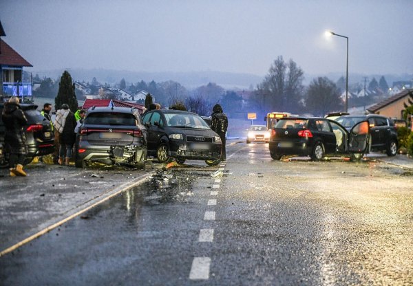 Nach einem Unfall bei Glatteis mit mehreren Fahrzeugen in Baden-Württemberg stehen Helfer und Beteiligte an den Autos auf einer Straße. - © Jason Tschepljakow/dpa