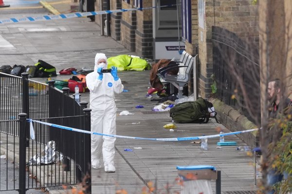 Kleidung und Rucksäcke auf dem Boden: Am Bahnhof der Stadt Huntingdon dauern die Ermittlungen an. - © Joe Giddens/PA Wire/dpa