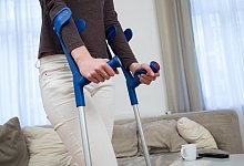 Eine Frau läuft mit Gehhilfen zu Hause - Christin Klose/dpa-tmn