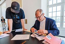 Volker Beck betrachtet die umstrittene Brosch&uuml;re der Initiative &laquo;Archives des luttes des femmes en Alg&eacute;rie&raquo; auf der documenta - Andreas Arnold/dpa