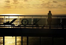 Schiffsreisende an Deck bei Sonnenuntergang - Andrea Warnecke/dpa-tmn