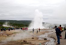 Touristen bestaunen den isl&auml;ndischen Geysir Strokkur - Foto: Steffen Trumpf/dpa/Archivbild