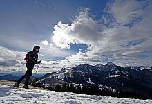 Ein Mann wandert in einer Berglandschaft mit Schnee - Foto: Uwe Lein/dpa/dpa-tmn