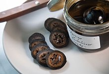 Schwarze Waln&uuml;sse in Gew&uuml;rzsirup auf einem Teller - Christin Klose/dpa-tmn