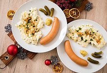 Zwei Teller mit W&uuml;rstchen und Kartoffelsalat. - Foto: Christin Klose/dpa-tmn