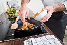 Mann brät Fleisch in einer Pfanne - Christin Klose/dpa-tmn