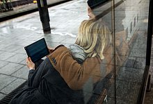 Ein Paar sieht auf ein Tablet am Bahnhof - Christin Klose/dpa-tmn