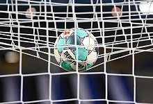 Ein Fußball liegt vor der Partie im Netz. - Friso Gentsch/dpa/Symbolbild