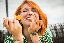 Frau cremt ihr Gesicht mit Sonnencreme ein - Christin Klose/dpa-tmn