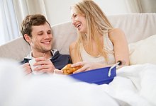 Paar genie&szlig;t ein Fr&uuml;hst&uuml;ck im Bett - Christin Klose/dpa-tmn