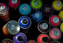 Leere Spraydosen stehen in einer Kiste - Franziska Gabbert/dpa-tmn