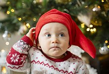 Cute baby boy wearing Santa hat on Christmas day at home - picture alliance / Westend61