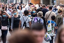 Menschen in einer Einkaufsstra&szlig;e - Foto: Marius Becker/dpa
