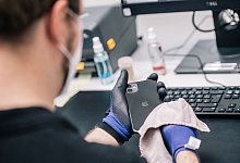 Ein Mitarbeiter überprüft ein refurbished Iphone - Zacharie Scheurer/dpa-tmn