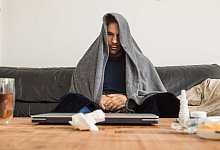 Ein Mann sitzt mit Erkältung auf der Couch - Christin Klose/dpa-tmn