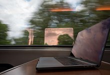 Ein Laptop auf einem Tisch in einem Zug - Christophe Gateau/dpa