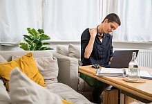 Person mit Nackenverspannung vorm Laptop - Christin Klose/dpa-tmn