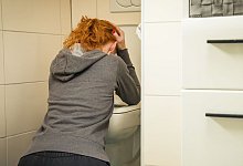 Frau kniet vor einer Toilette - Christin Klose/dpa-tmn