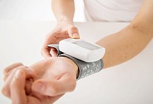 Frau misst ihren Blutdruck am Handgelenk - Christin Klose/dpa-tmn