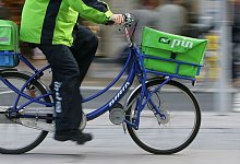 Briefzusteller des Dienstleisters Pin Mail auf einem Fahrrad - Uwe Anspach/dpa/dpa-tmn