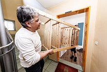 Mann trägt ein Regal durch ein Treppenhaus - Markus Scholz/dpa-tmn