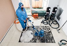 Eine Person im Schutzanzug - Markus Scholz/dpa-tmn