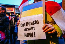 Ein Demonstrant h&auml;lt ein Schild mit der ukrainischen Flagge und der Aufschrift &laquo;Russland jetzt abschneiden!&raquo;. - Filip Radwanski/SOPA Images via ZUMA Press Wire/dpa