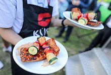 Bedienung trägt Teller mit Essen zu Gästen - Jan Woitas/dpa/dpa-tmn