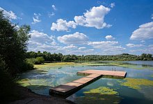 Badesee mit Steg im Sonnenschein - Nicolas Armer/dpa/dpa-tmn