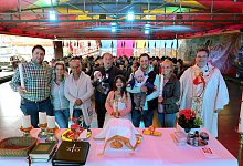 Die Schausteller-Familie Heitmann und Freunde haben sich auf der Fl&auml;che des Autoscooters zum Gottesdienst versammelt. Pfarrer Sascha Ellinghaus hat hier seinen Altar aufgebaut. - Frank-Michael Kiel-Steinkamp