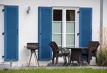 Gartenm&ouml;bel und ein Grill stehen auf der Terrasse vor einem Haus - Stefan Sauer/dpa/dpa-tmn