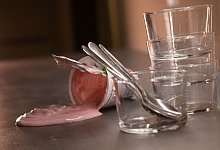 Joghurt fließt aus einem umgekippten Becher - Christin Klose/dpa-tmn